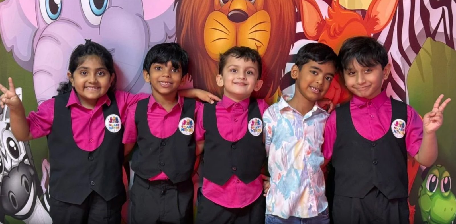 Smart Minds children in front of a colourful jungle mural